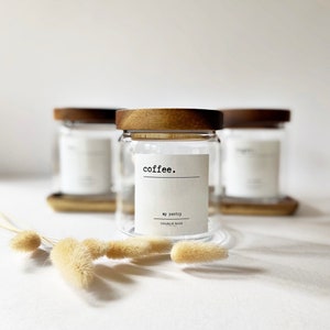 May include: Three glass jars with wooden lids and labels. The centre jar has a label that reads "coffee. my pantry CHARLIE ROSE STUDIO".