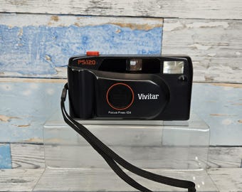 Câmera VIVITAR PS-120 de filme 35 mm, tipo "apontar e disparar", com alça e foco livre.