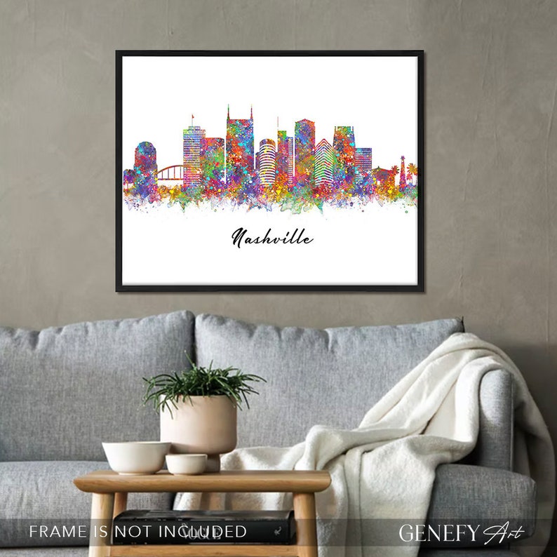May include: A colorful watercolor painting of the Nashville skyline. The city's iconic buildings are depicted in a vibrant palette of colors, with a splash of paint effect. The word "Nashville" is written in black script at the bottom of the image.