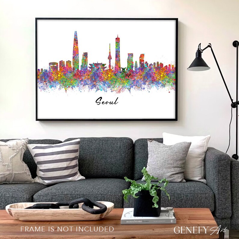 May include: A watercolor painting of the Seoul skyline with colorful splashes of paint. The city's iconic skyscrapers are visible, including the Lotte World Tower and the N Seoul Tower. The text "Seoul" is written in black cursive at the bottom of the painting.