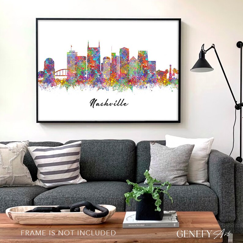 May include: A watercolor painting of the Nashville skyline with a colorful splatter effect. The city's iconic buildings are depicted in black silhouette against a white background. The word "Nashville" is written in black cursive below the skyline.