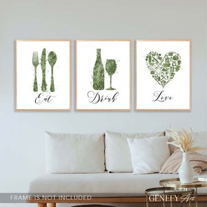 May include: Three green watercolor prints with white backgrounds. The first print features a fork, knife, and spoon with the word "Eat" below. The second print features a wine bottle and wine glass with the word "Drink" below. The third print features a heart made of kitchen icons with the word "Love" below.