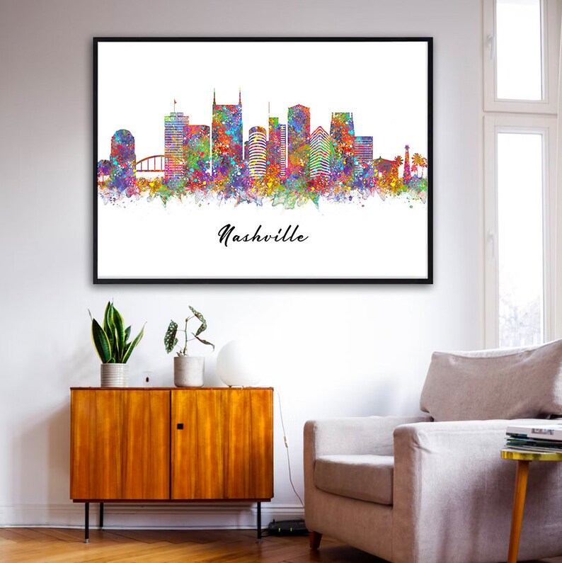 May include: A watercolor painting of the Nashville skyline with colorful splashes of paint. The city's iconic buildings are depicted in silhouette, with the text "Nashville" written below.