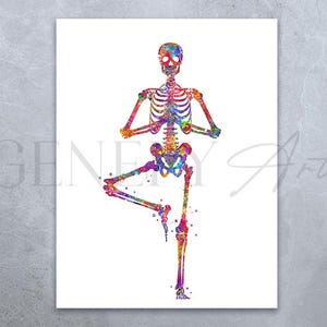 Op de afbeelding: Een kleurrijk aquarel schilderij van een skelet in een yoga pose. Het skelet staat in een boom pose met zijn rechterbeen omhoog en zijn armen uitgestrekt. Het schilderij is gemaakt in verschillende kleuren, waaronder roze, blauw, groen en geel.