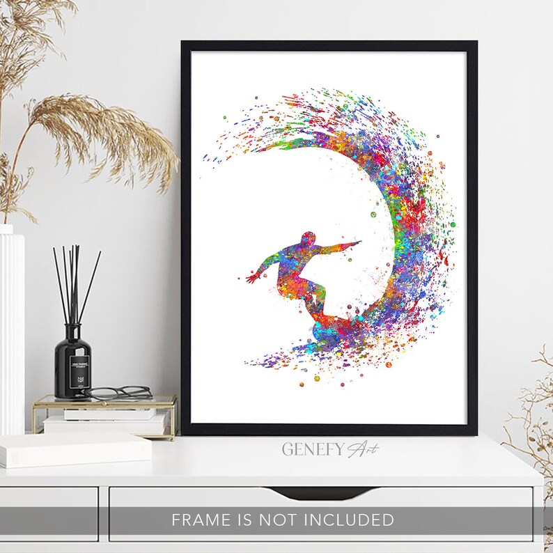 May include: A colourful watercolour painting of a surfer riding a wave. The surfer is silhouetted in black and the wave is a vibrant rainbow of colours. The painting is framed in black and has the text "GeneFy Art" at the bottom.