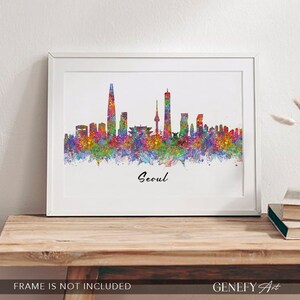 May include: A watercolor painting of the Seoul skyline with a rainbow of colors. The city's iconic skyscrapers are visible, including the Lotte World Tower and the N Seoul Tower. The text "Seoul" is written in cursive at the bottom of the painting.