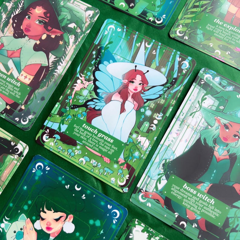 Peut inclure: Un ensemble de cartes d'oracle illustr&eacute;es, domin&eacute;es par des tons verts et turquoise. Chaque carte pr&eacute;sente un personnage de sorci&egrave;re avec des inscriptions comme "touch grass" et "boss witch". Les cartes sont dispos&eacute;es sur une surface verte.