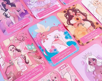 May include: A collection of pink and pastel-colored oracle cards featuring illustrations of women and floral elements. Each card has a unique design and text, including phrases like "travel, movement, exploration" and "a soul connection, magical love."