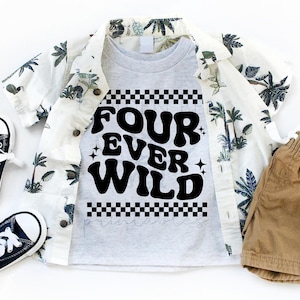 Könnte beinhalten: Ein Kinder-Outfit mit einem grauen T-Shirt mit dem schwarzen Text "FOUR EVER WILD", einem weißen Hemd mit tropischem Aufdruck und khakifarbenen Shorts. Zwei Paar marineblaue Turnschuhe vervollständigen das Ensemble.