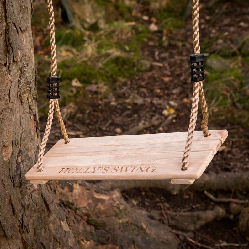 May include: A wooden swing set with rope and a personalized inscription that reads "HOLLY'S SWING".