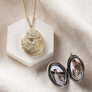 Peut inclure: Un collier avec un médaillon en or orné d'un motif floral. Le médaillon est ouvert et montre deux photos d'un couple.