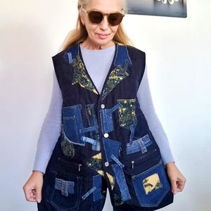 Peut inclure: Un gilet en jean bleu foncé avec un motif patchwork. Le gilet présente divers tons de patchs en jean bleu, des poches et des fermetures à boutons. Le gilet est porté sur une chemise à manches longues bleu clair et un jean.