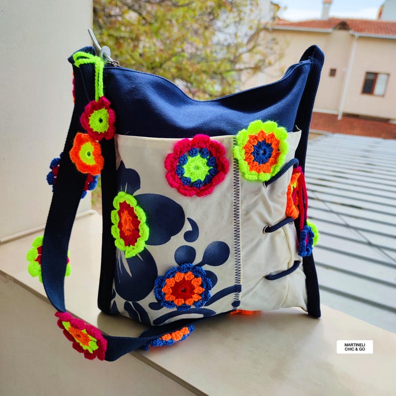 K&ouml;nnte beinhalten: Eine wei&szlig;e Keramik-Tasse mit schwarzem Henkel und dem Text "But First, Coffee" in fetter, schwarzer Schrift. Die Tasse steht vor einem verschwommenen Hintergrund, der eine gem&uuml;tliche Umgebung suggeriert.