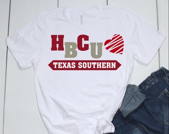 Op de afbeelding: Wit T-shirt met de tekst "HBCU" in rode en beige letters, een rood hart met witte strepen en de tekst "TEXAS SOUTHERN" in rode letters.
