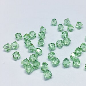 Chrysolite 6mm Bicone SWAROVSKI® Crystal Beads #5301 package of 50. Light Pastel Green color Genuine Austrian Crystal. Bulk. #5328.