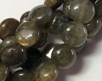 May include: A close-up of a strand of polished labradorite gemstone beads. The beads are a mix of dark grey and brown with iridescent flashes of blue and green. The beads are round and smooth, ideal for jewellery making.