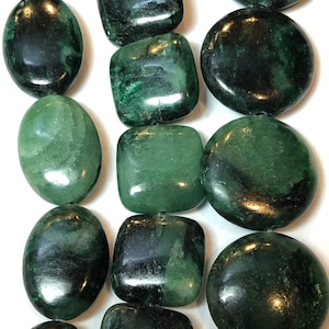 May include: An assortment of polished green jade beads in various shapes: oval, square, and round. The beads have a dark green color with lighter green marbling, and are strung together. These beads are suitable for jewelry making.
