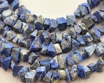 Könnte beinhalten: Nahaufnahme von mehreren Strängen roher, unregelmäßig geformter Lapislazuli-Perlen. Die Perlen sind tiefblau mit weißen und grauen Flecken, wodurch ein natürliches, strukturiertes Aussehen entsteht. Ideal für die Schmuckherstellung.