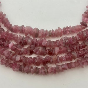 Raw Pink Tourmaline Gemstone beads. 15” strand of 6-10mm (dia.) raw pink chips, roughly 140 per strand.