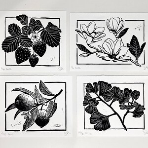 four prints that match thematically, including strawberries. there is also a magnolia branch, lemon branch with two lemons and two blossoms, and a ginkgo branch. the prints have borders and are black ink on white paper.