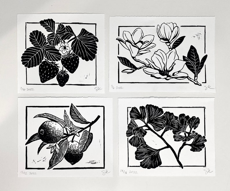 four prints that match thematically, including strawberries. there is also a magnolia branch, lemon branch with two lemons and two blossoms, and a ginkgo branch. the prints have borders and are black ink on white paper.