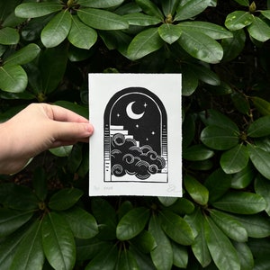 Straight-on view of the nighttime arch print, held in front of dark green rhododendron leaves. It measures five inches wide and seven inches tall.