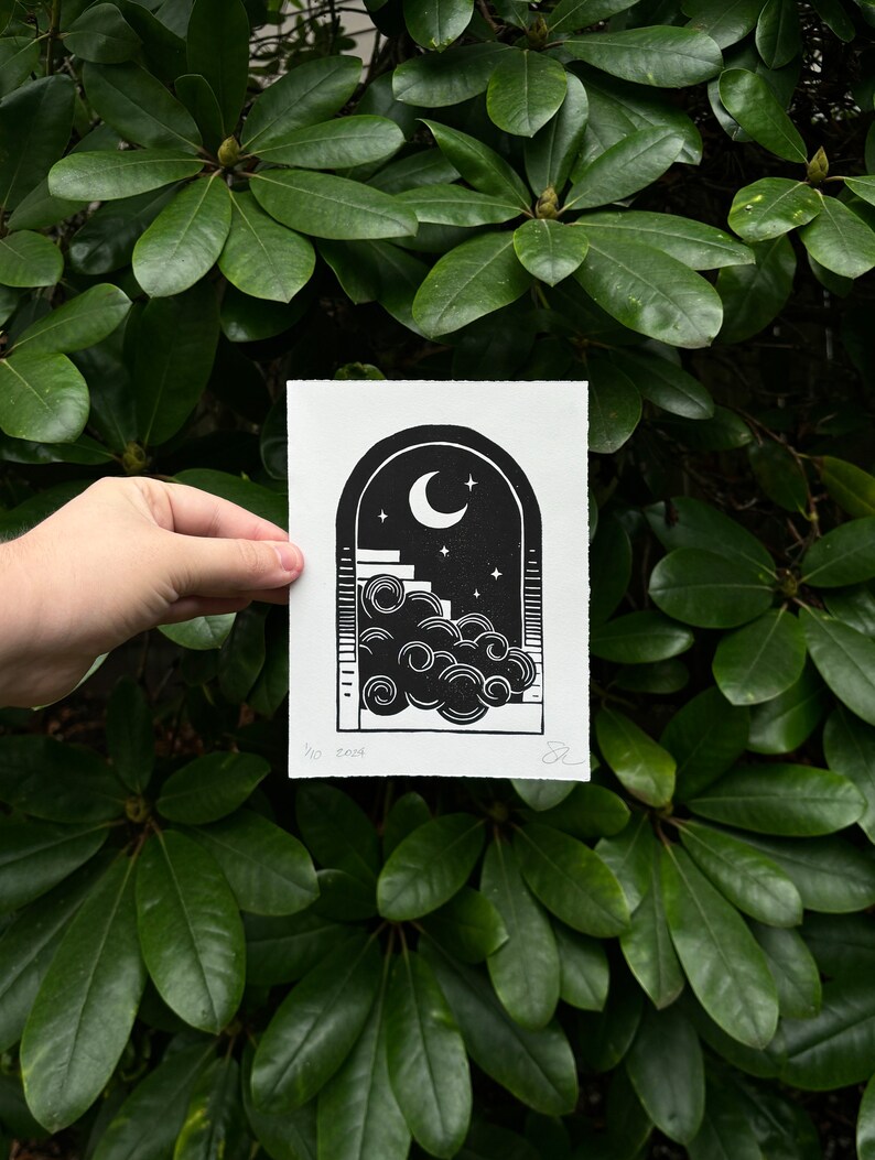 Straight-on view of the nighttime arch print, held in front of dark green rhododendron leaves. It measures five inches wide and seven inches tall.