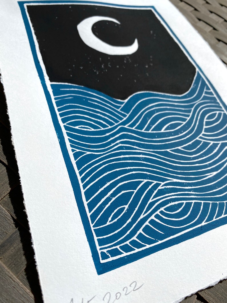A closeup of the waves on the print, highlighting the blue ink and white lines between where the paper is showing through. The edges of the paper are torn rather than cut, giving a rustic artful look.