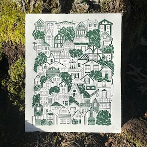 The print sitting at the base of a mossy tree in direct sunlight