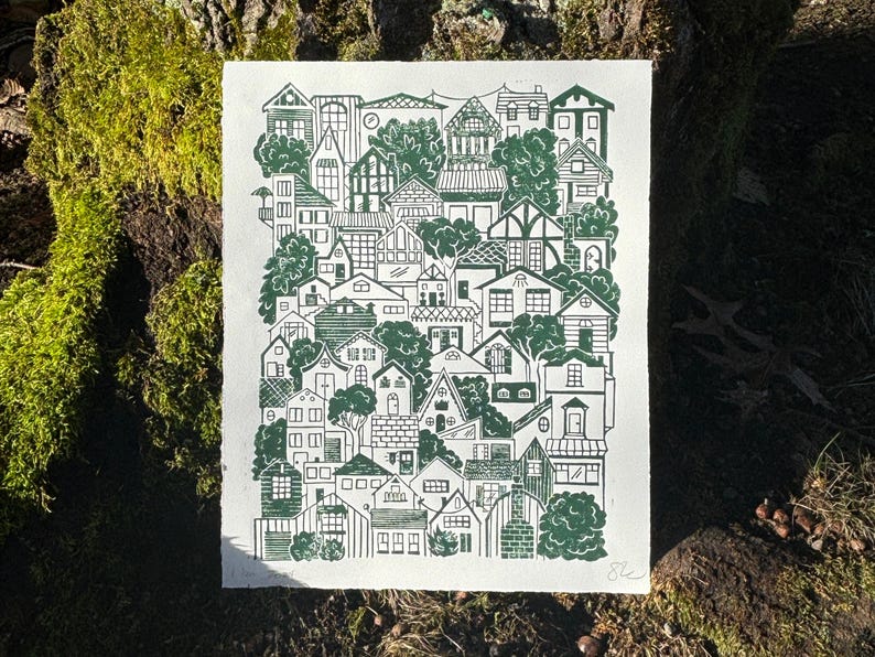 The print sitting at the base of a mossy tree in direct sunlight