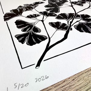 closeup of the lower left corner with the edition and year of the print written in pencil. there is a thin black border around the print with an inch of space between the border and the print edge all the way around. the branch overlaps in front of the border in four places