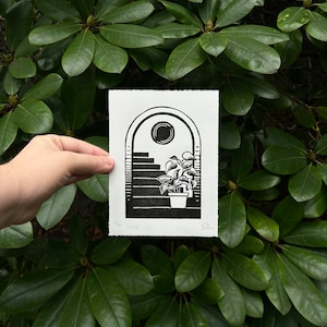 Straight-on view of the daytime arch print, held in front of dark green rhododendron leaves. It measures five inches wide and seven inches tall.