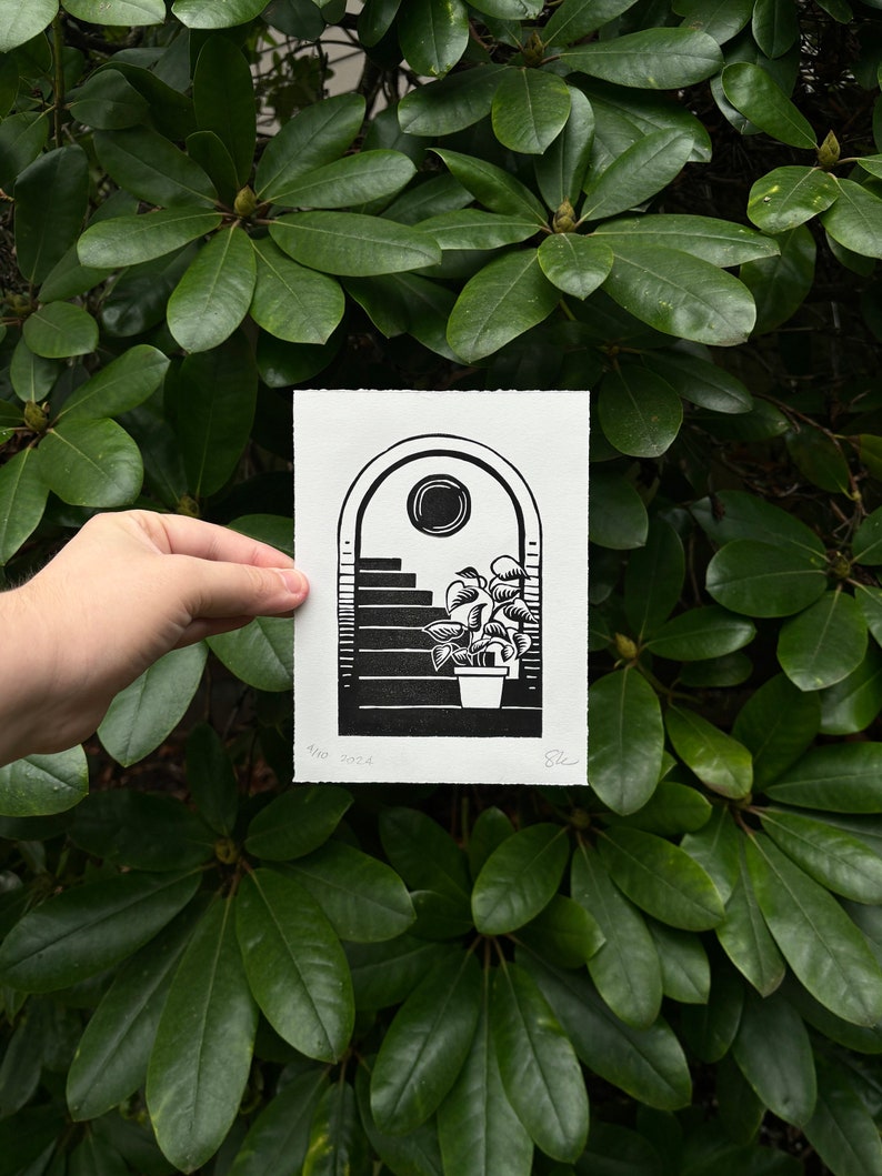 Straight-on view of the daytime arch print, held in front of dark green rhododendron leaves. It measures five inches wide and seven inches tall.