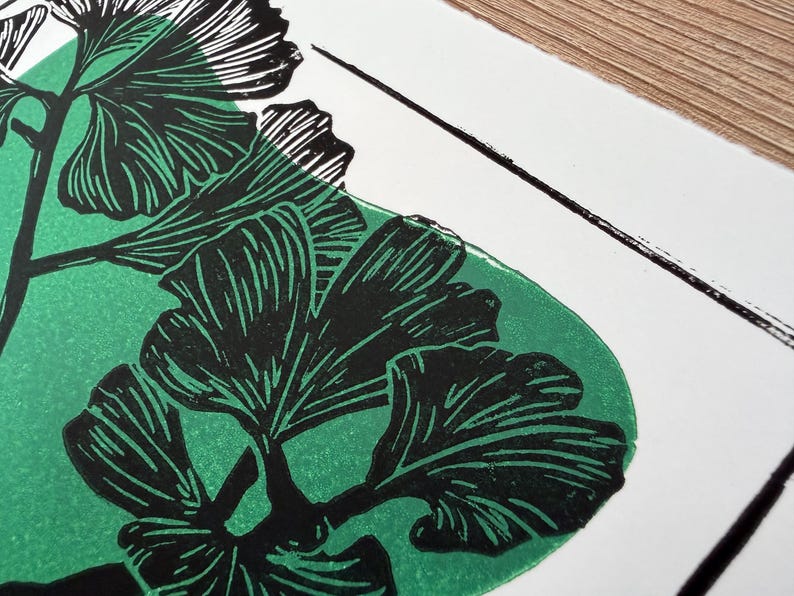 a close-up of the print, showing the detail of the leaves. the leaves are black with thin white lines to show veins and texture. the green blob behind the black ink doesnt show through the black but adds dimension.