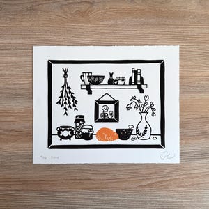 the same print laying on a light wood background.