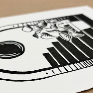 Angled closeup of the daytime linocut print. The outermost half-inch of the arch has a shading pattern on the left and right sides made of horizontal lines, going from black at the bottom to white on top.