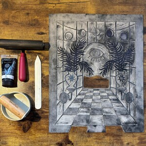 The linoleum block, ink, and rollers used to make this print. The block is a reverse image of the print.