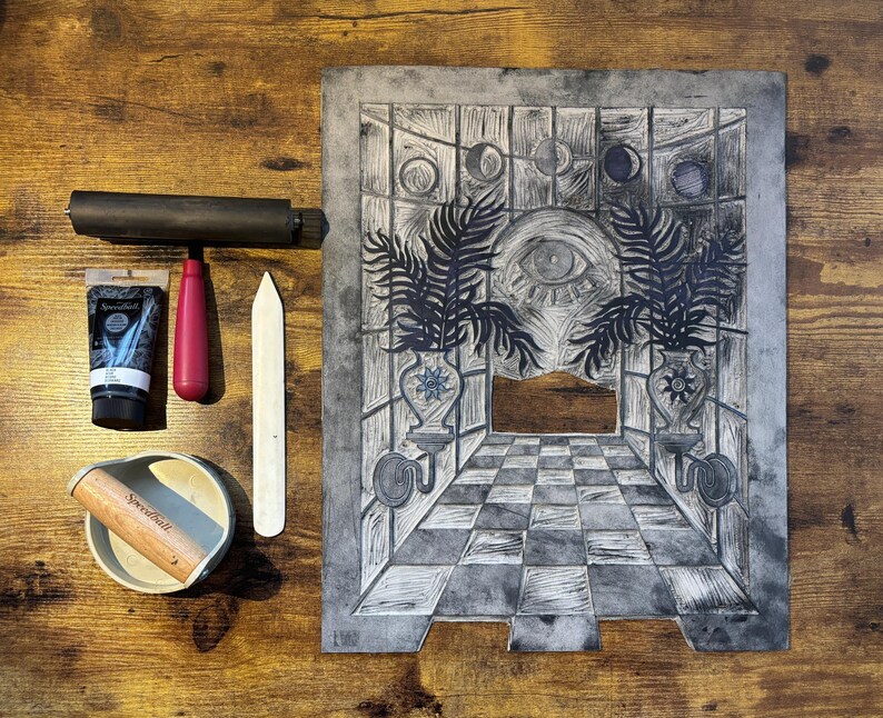 The linoleum block, ink, and rollers used to make this print. The block is a reverse image of the print.