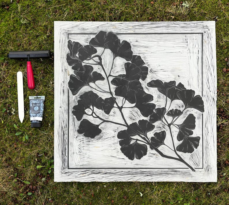 The linoleum block, ink, and rollers used to make this print. The block is a reverse image of the print.