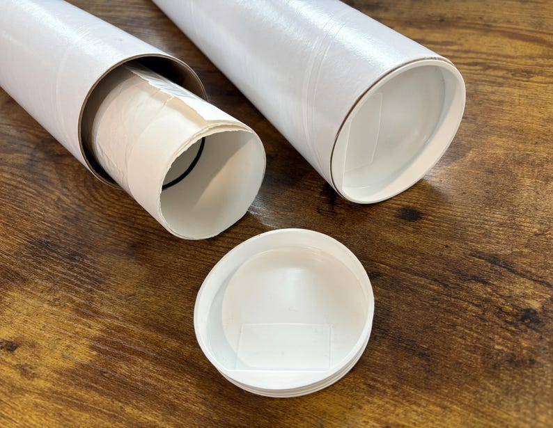 the print packaged for shipping. it is rolled into a tube and put inside a plastic sleeve. the plastic sleeved print is sticking out of a 3 inch mailing tube made of thick sturdy cardboard. another tube next to it is sealed with a plastic lid