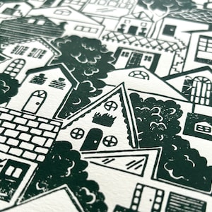 An angled close-up of the middle of the print. There is an A-frame house with round windows, a house with barn door-style window shutters, and a staircase zigzagging five times between two houses