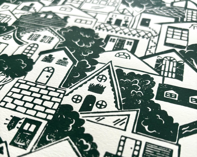 An angled close-up of the middle of the print. There is an A-frame house with round windows, a house with barn door-style window shutters, and a staircase zigzagging five times between two houses