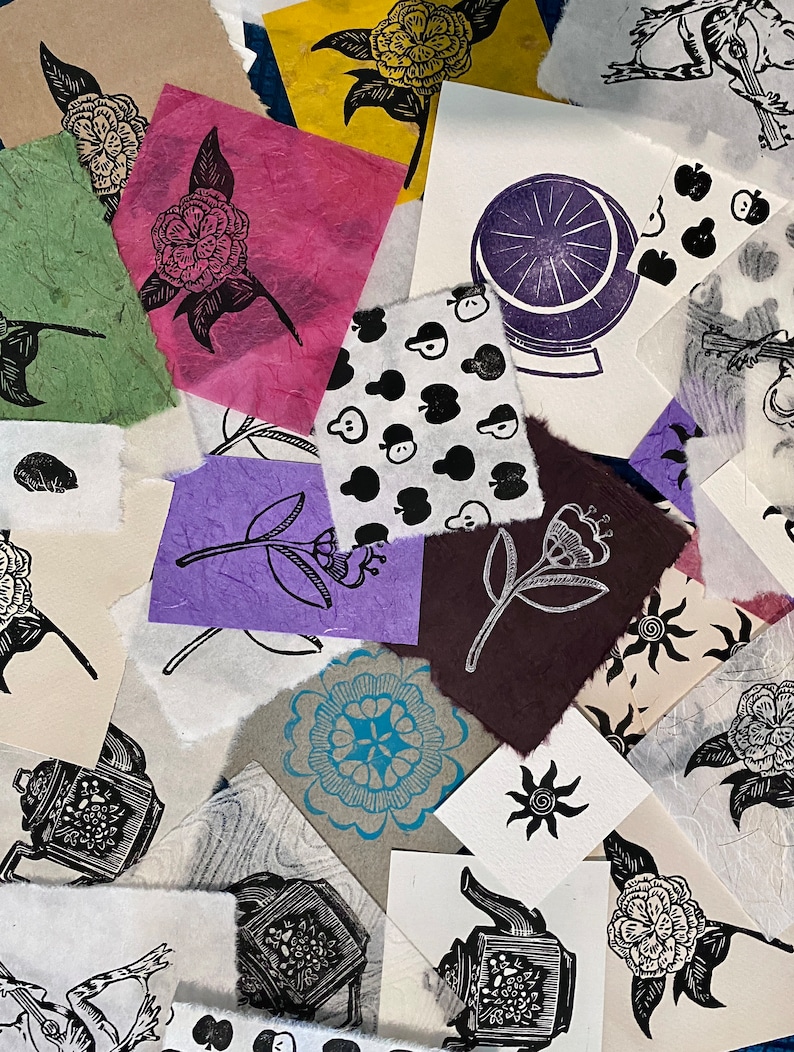 May include: A collection of handmade paper prints featuring various designs, including floral motifs, geometric patterns, and whimsical illustrations. The prints are in black and white, with some featuring pops of color like blue, purple, and red.