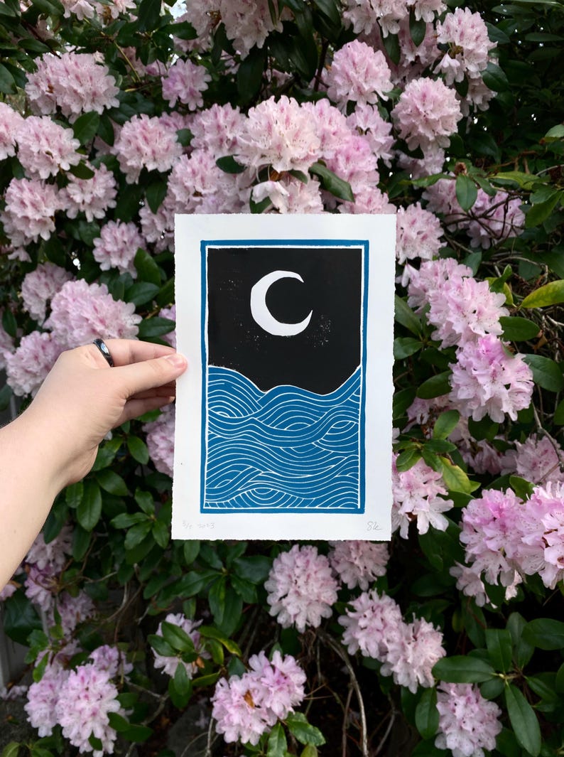 The same print held in front of pink rhododendron leaves.