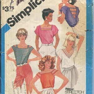 May include: Vintage Simplicity sewing pattern for one-yard tops, size 10. The cover features illustrations of women wearing various tops in different colors, including pink, blue, and orange. The pattern includes the text "STRETCH knit".