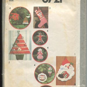 Puede incluir: Sobre de patrón Simplicity vintage con proyectos de costura navideños. El sobre muestra varios diseños festivos, incluyendo un adorno de Papá Noel, un calcetín navideño y un adorno de hombre de jengibre. El texto "Simplicity 8721" se muestra de forma destacada.