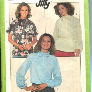 May include: Simplicity pattern 8293 featuring three blouse designs. The pattern includes a floral print blouse, a cream-colored blouse, and a light blue blouse. The pattern is for a medium size 14-16.