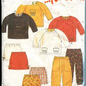 May include: A vintage New Look sewing pattern for children's clothing. The pattern features illustrations of long-sleeved shirts, skirts, and pants in various colors, including yellow, orange, and brown. The shirts have cat face designs. The text "NEW LOOK ...for Kids" is visible.