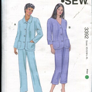May include: Kwik Sew pattern 3392 for misses' sizes XS-XL. The pattern features two pajama sets, one in light blue and the other in lavender. Each set includes a button-up top with pockets and matching pants. The pattern is designed by Kerstin Martensson.