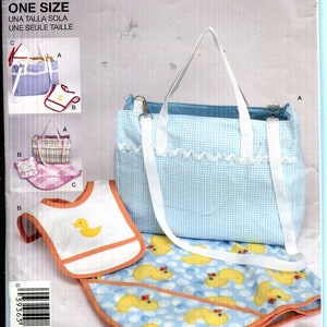 May include: Simplicity pattern 2838 for a baby bag, bib, and changing mat. The bag is light blue gingham with white straps. The bib is white with an orange trim and a yellow duck. The changing mat has a blue background with yellow ducks.